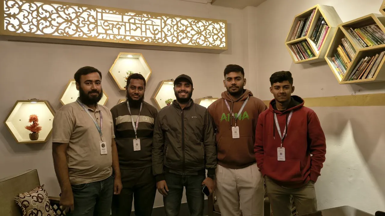 five teammates standing together in an office wearing id badges